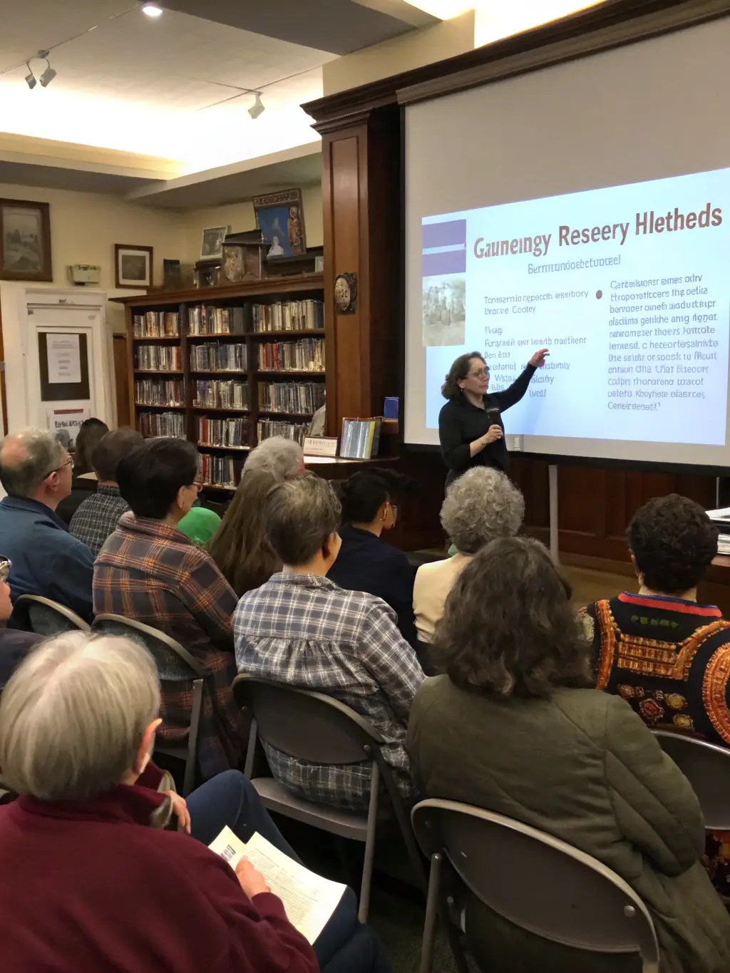 A photo of a group attending a workshop on local history at the library, with a historian presenting historical documents and artifacts.
